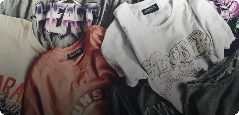 A pile of colorful printed t-shirts with various designs and logos.