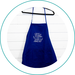 Blue apron with motivational text hanging on a white wall.